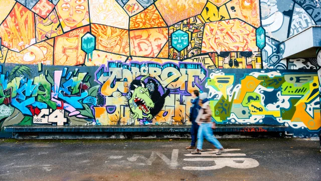 Couple se baladant devant une fresque Street art à Saint-Julien-en-Genevois